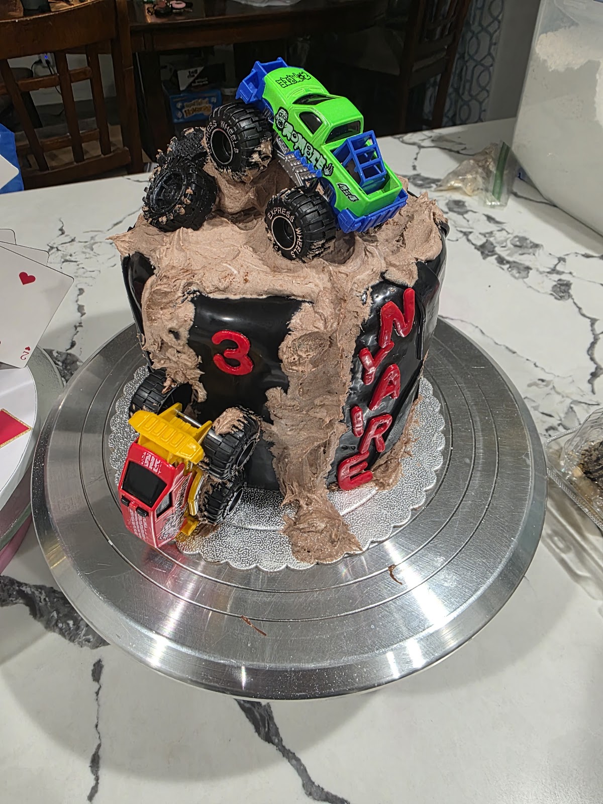 Monster truck third birthday cake with chocolate mud finish and toy trucks