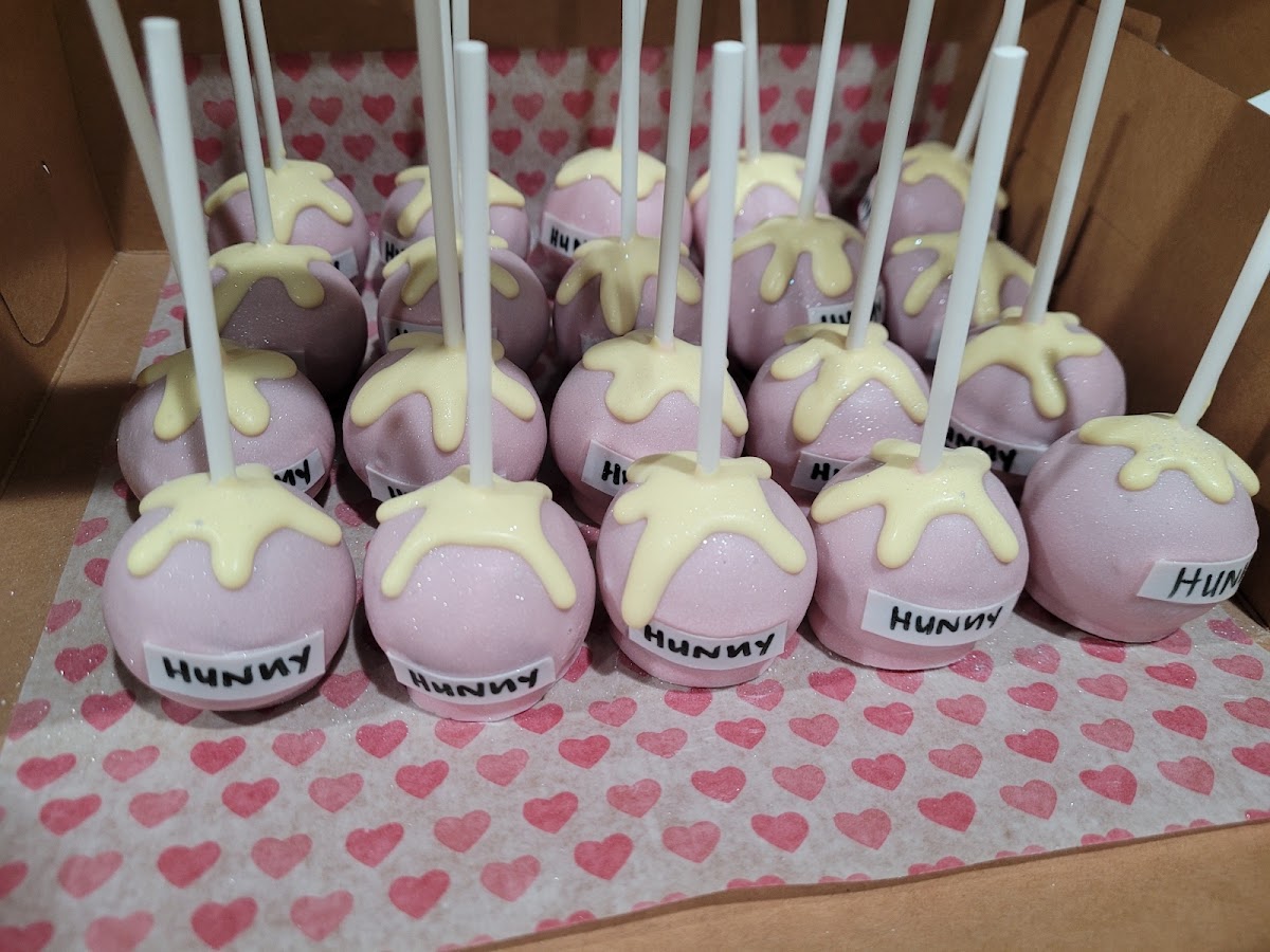 Winnie the Pooh honey pot cake pops in pink with a honey drizzle finish