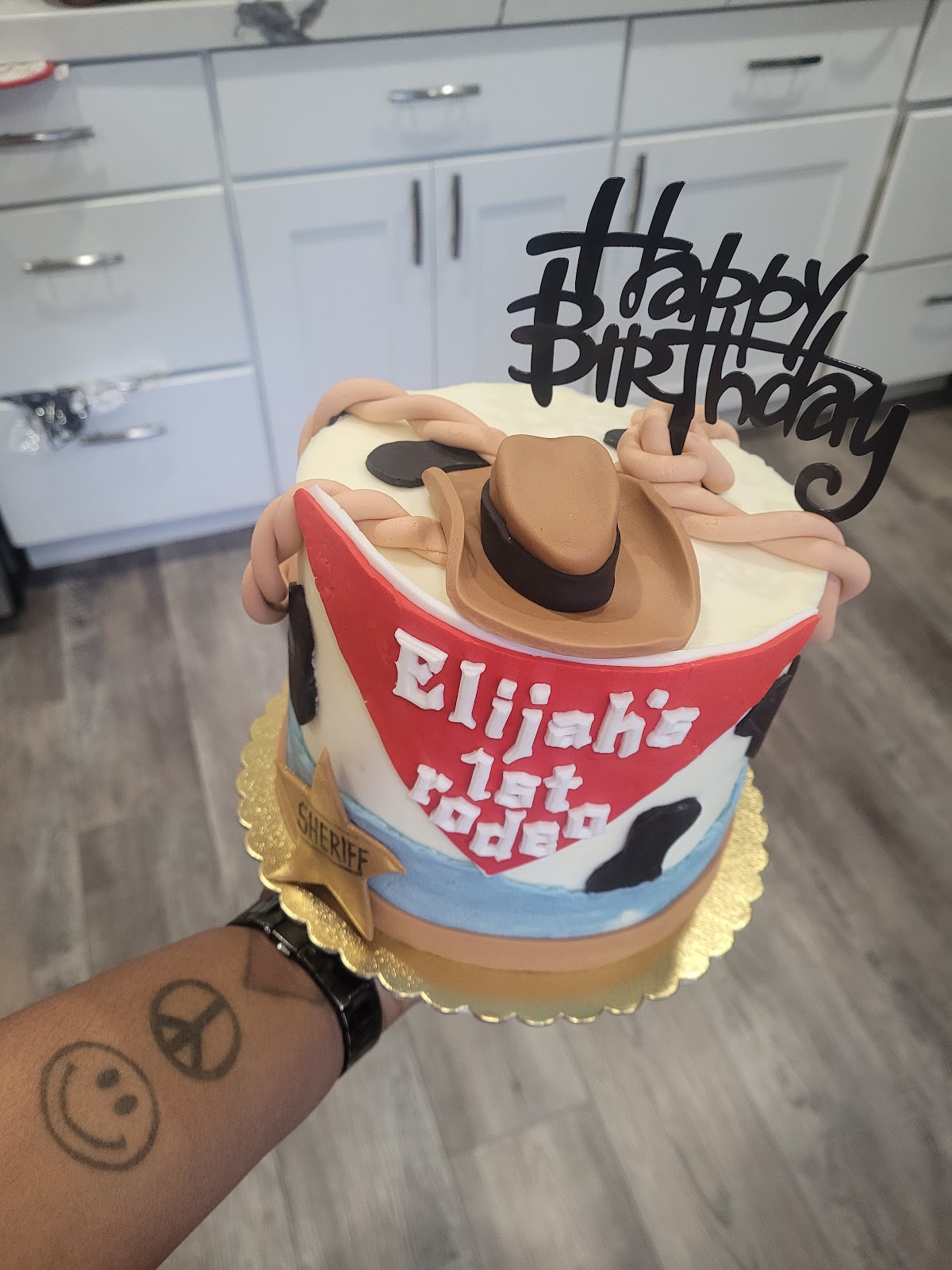 Cowboy themed first birthday cake reading Elijah's 1st Rodeo with a sheriff star