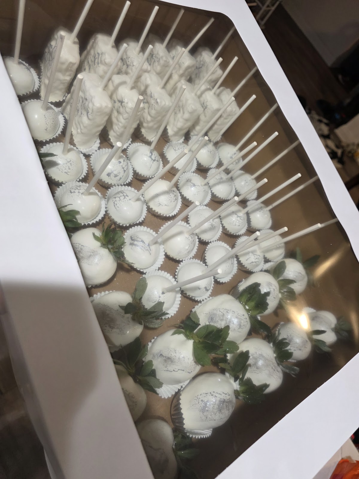 White chocolate dessert spread of cake pops, dipped strawberries and marbled treats
